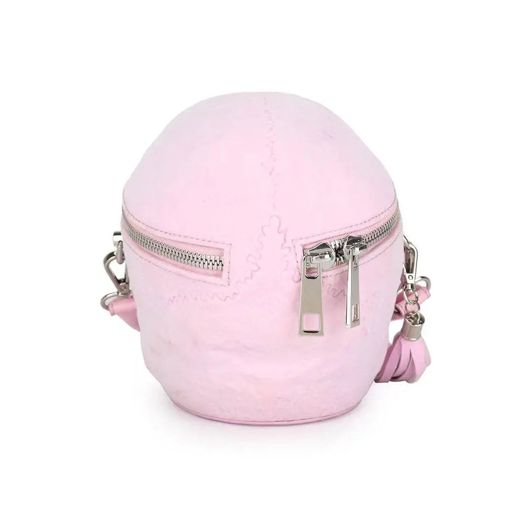 Pink 3D skull-shaped suede crossbody bag with silver zippers.