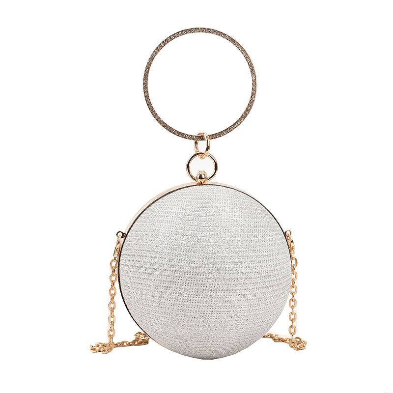 Shimmery silver spherical evening clutch with a large gold ring handle and chain.