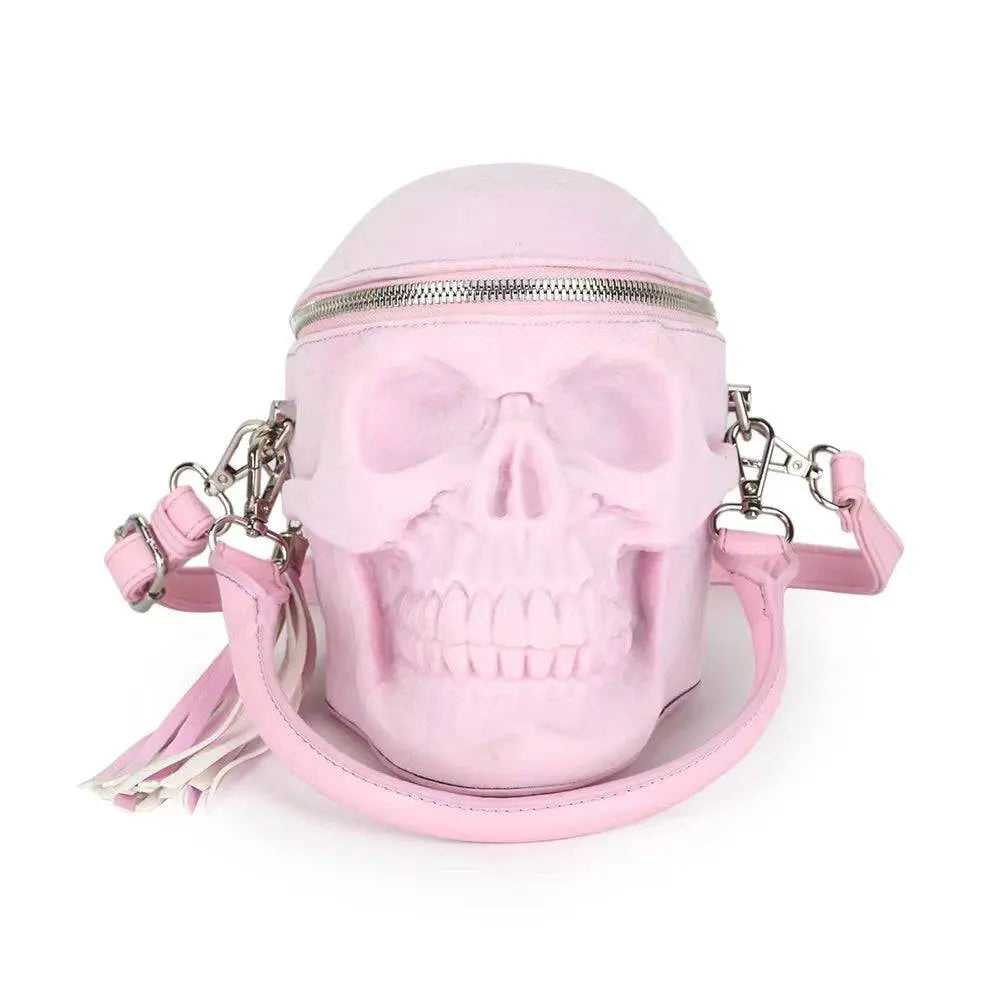 Pink suede 3D skull crossbody bag with a top zipper and tassels.