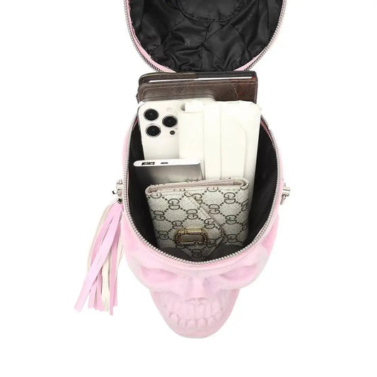 Open pink suede 3D skull bag filled with a phone and wallet.