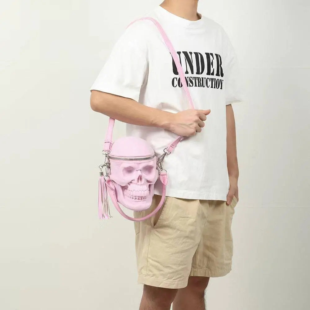 Pink 3D skull suede crossbody bag with tassels on a person.
